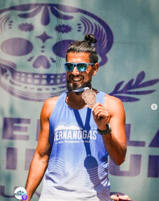Hernán Ogas en el podio con la medalla de campeón y la musculosa oficial del equipo